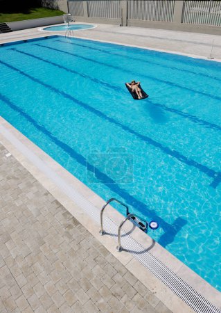 Téléchargez les photos : Belle femme relaxante à la piscine - en image libre de droit