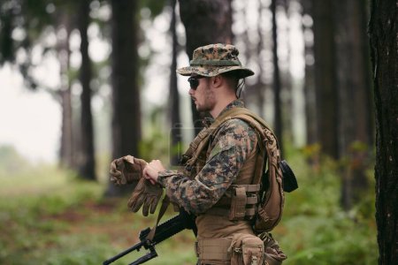 Téléchargez les photos : Soldat préparant l'équipement tactique et de communication pour la bataille d'action - en image libre de droit