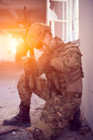 Foto de Soldado en acción cerca de la ventana cambiante revista y cubriéndose - Imagen libre de derechos