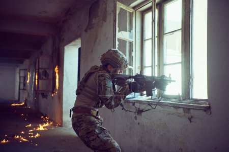 Téléchargez les photos : Soldat en action près d'une fenêtre changeant de magazine et se mettant à couvert - en image libre de droit