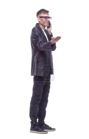 Photo for Side view. guy with a smartphone standing in front of a white - Royalty Free Image