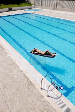Téléchargez les photos : Belle femme relaxante à la piscine - en image libre de droit