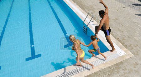 Photo for Happy young family have fun on swimming pool - Royalty Free Image