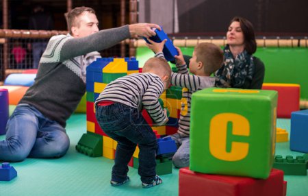 Photo for Young parents and kids having fun at childrens playroom - Royalty Free Image