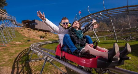 Téléchargez les photos : "couple conduite sur les montagnes russes alpines" - en image libre de droit