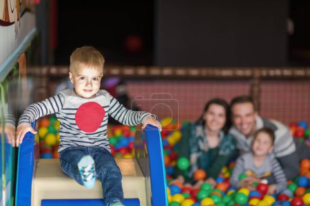 Photo for Parents and kids playing in the pool with colorful balls - Royalty Free Image