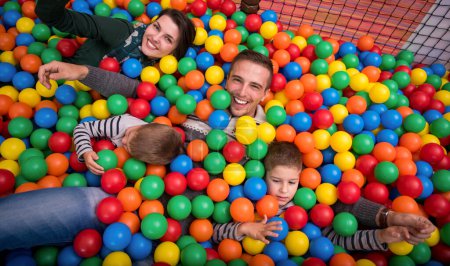 Photo for Parents and kids playing in the pool with colorful balls - Royalty Free Image