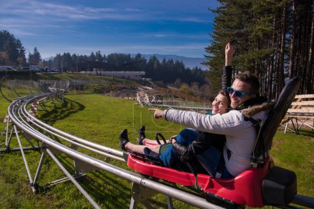 Téléchargez les photos : Couple conduite sur les montagnes russes alpines - en image libre de droit