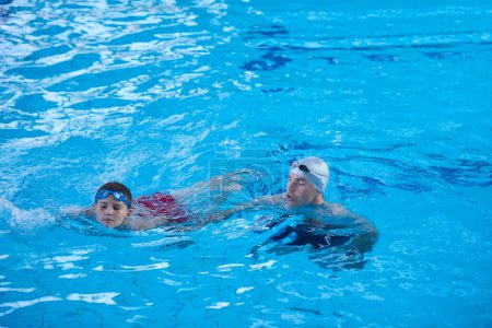 Téléchargez les photos : Groupe de l'enfant à la classe de l'école de piscine - en image libre de droit