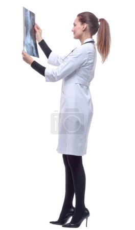 Foto de "Vista lateral. doctora sonriente mirando una radiografía." - Imagen libre de derechos