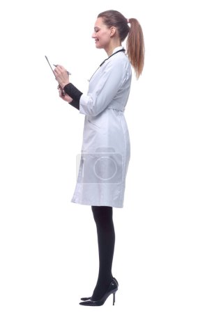 Téléchargez les photos : "vue latérale. jeune femme médecin prendre des notes dans le presse-papiers." - en image libre de droit