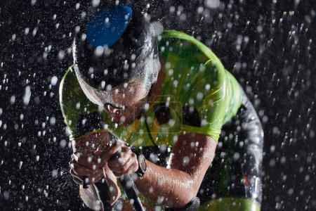 Photo for Triathlon athlete riding bike  fast on rainy night - Royalty Free Image
