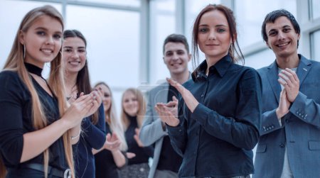 Téléchargez les photos : Jeunes employés applaudissant ensemble debout dans le bureau - en image libre de droit