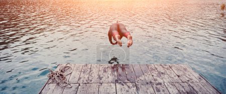 Téléchargez les photos : Athlète de triathlon sautant dans l'eau et commençant par l'entraînement - en image libre de droit