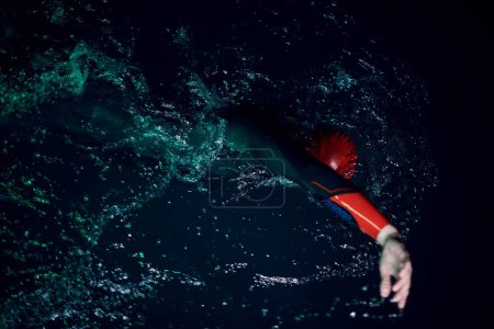Foto de Atleta de triatlón real nadando en la noche oscura - Imagen libre de derechos