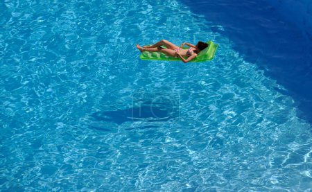 Téléchargez les photos : Jeune femme se détendre à la piscine - en image libre de droit