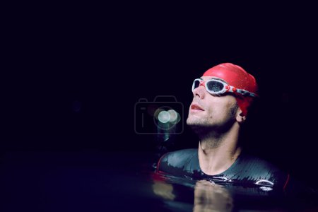Foto de Auténtico nadador de triatleta teniendo un descanso durante el entrenamiento duro en la noche - Imagen libre de derechos