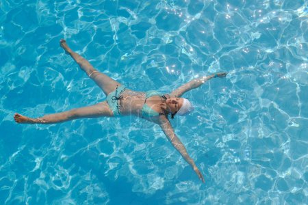 Téléchargez les photos : Jeune femme se détendre à la piscine - en image libre de droit