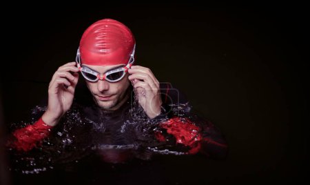 Photo for Authentic triathlete swimmer having a break during hard training on night - Royalty Free Image