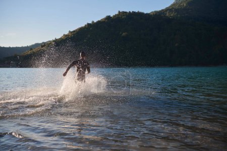 Photo for Triathlon athlete starting swimming training on lake - Royalty Free Image