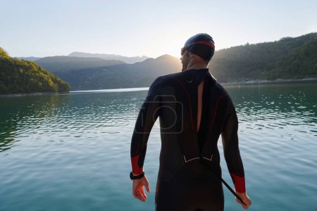 Foto de Atleta de triatlón comenzando a nadar entrenamiento en el lago - Imagen libre de derechos