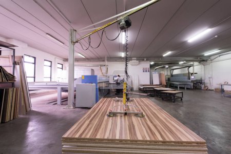 Téléchargez les photos : Worker in a factory of wooden furniture - en image libre de droit