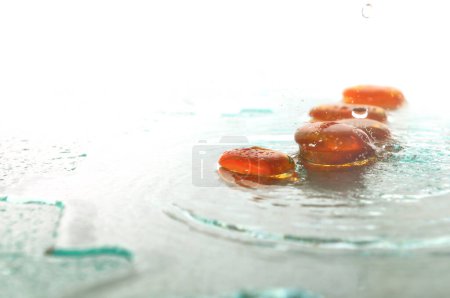 Photo for "isolated wet zen stones with splashing  water drops" - Royalty Free Image