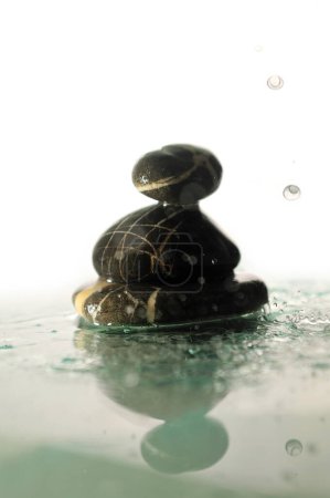 Téléchargez les photos : Pierres zen humides isolées avec éclaboussures gouttes d'eau - en image libre de droit