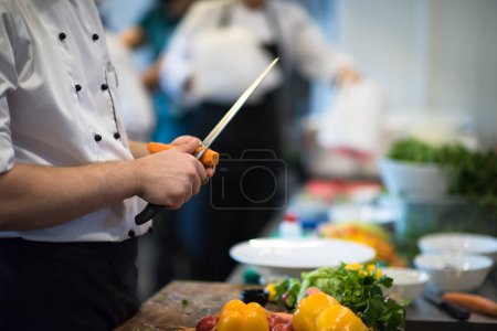 Photo for Chef hands cutting carrots - Royalty Free Image