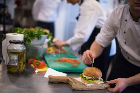 Téléchargez les photos : Chef finissant hamburger au restaurant cuisine - en image libre de droit