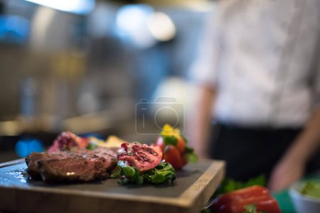 Photo for "Juicy slices of grilled steak on wooden board" - Royalty Free Image