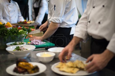 Foto de Equipo de cocineros y chefs preparando la comida - Imagen libre de derechos