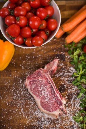 Photo for "top view of raw steak on wooden table" - Royalty Free Image