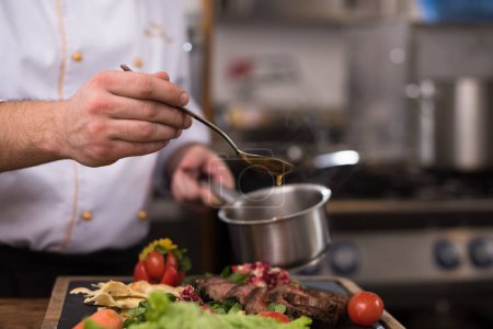 Téléchargez les photos : "Chef finition à la main assiette de viande de steak
" - en image libre de droit