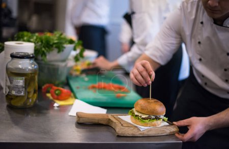 Téléchargez les photos : Chef finissant hamburger au restaurant cuisine - en image libre de droit