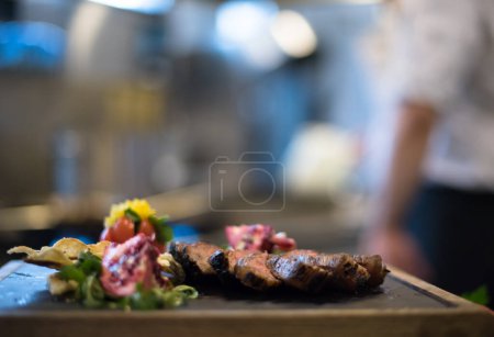 Foto de "Jugosas rebanadas de bistec a la parrilla sobre tabla de madera
" - Imagen libre de derechos