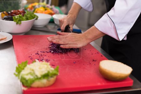 Téléchargez les photos : "chef hands cutting salad for burger" - en image libre de droit