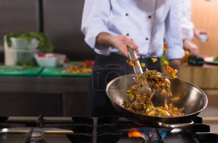 Photo for "chef flipping vegetables in wok" - Royalty Free Image