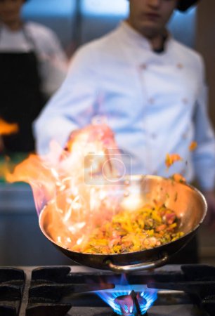 Photo for "Chef doing flambe on food" - Royalty Free Image