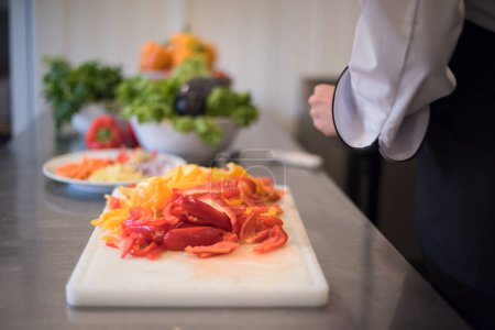 Téléchargez les photos : "Chef coupant des légumes frais et délicieux
" - en image libre de droit