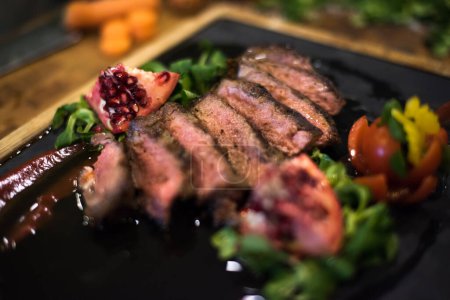 Photo for "Juicy slices of grilled steak on wooden board" - Royalty Free Image