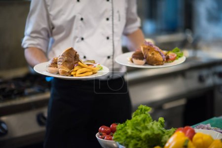 Foto de "Chef mostrando platos de sabrosas comidas
" - Imagen libre de derechos