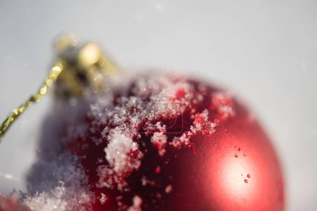 Foto de Bola roja de Navidad en nieve fresca. Concepto vacaciones de invierno - Imagen libre de derechos