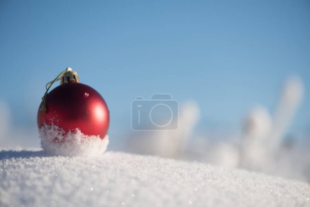 Téléchargez les photos : Boule de Noël rouge dans la neige fraîche. Concept vacances d'hiver - en image libre de droit
