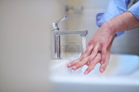Téléchargez les photos : "coronavirus mâle lavage des mains dans la salle de bain" - en image libre de droit