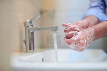 Photo for "coronavirus male washing hands in bathroom" - Royalty Free Image