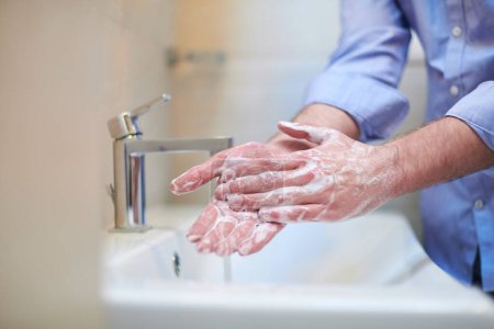 Téléchargez les photos : "coronavirus mâle lavage des mains dans la salle de bain" - en image libre de droit