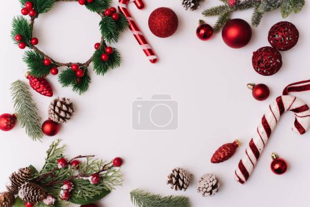 Téléchargez les photos : Cadre de Noël en branches de sapin, décorations rouges pour l'arbre. Papier peint de Noël. Pose plate, vue du dessus, espace de copie - en image libre de droit