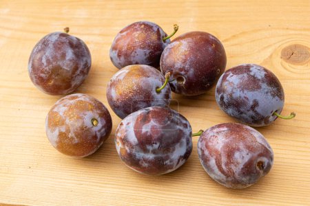 Photo for "Fresh juice plums on a wooden background" - Royalty Free Image