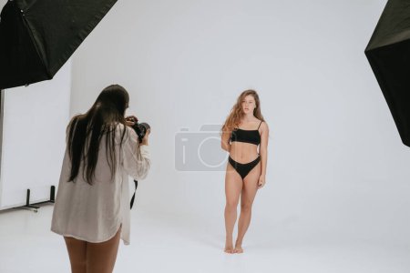 Photo for "Professional male photographer taking pictures of woman model" - Royalty Free Image